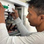 Electrician inspecting circuit breaker panel during home assessment