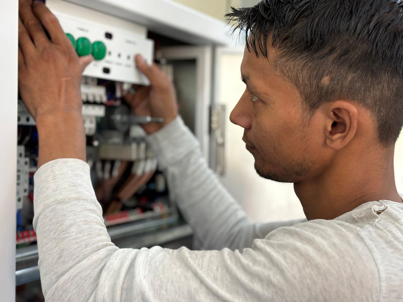 Electrician inspecting circuit breaker panel during home assessment